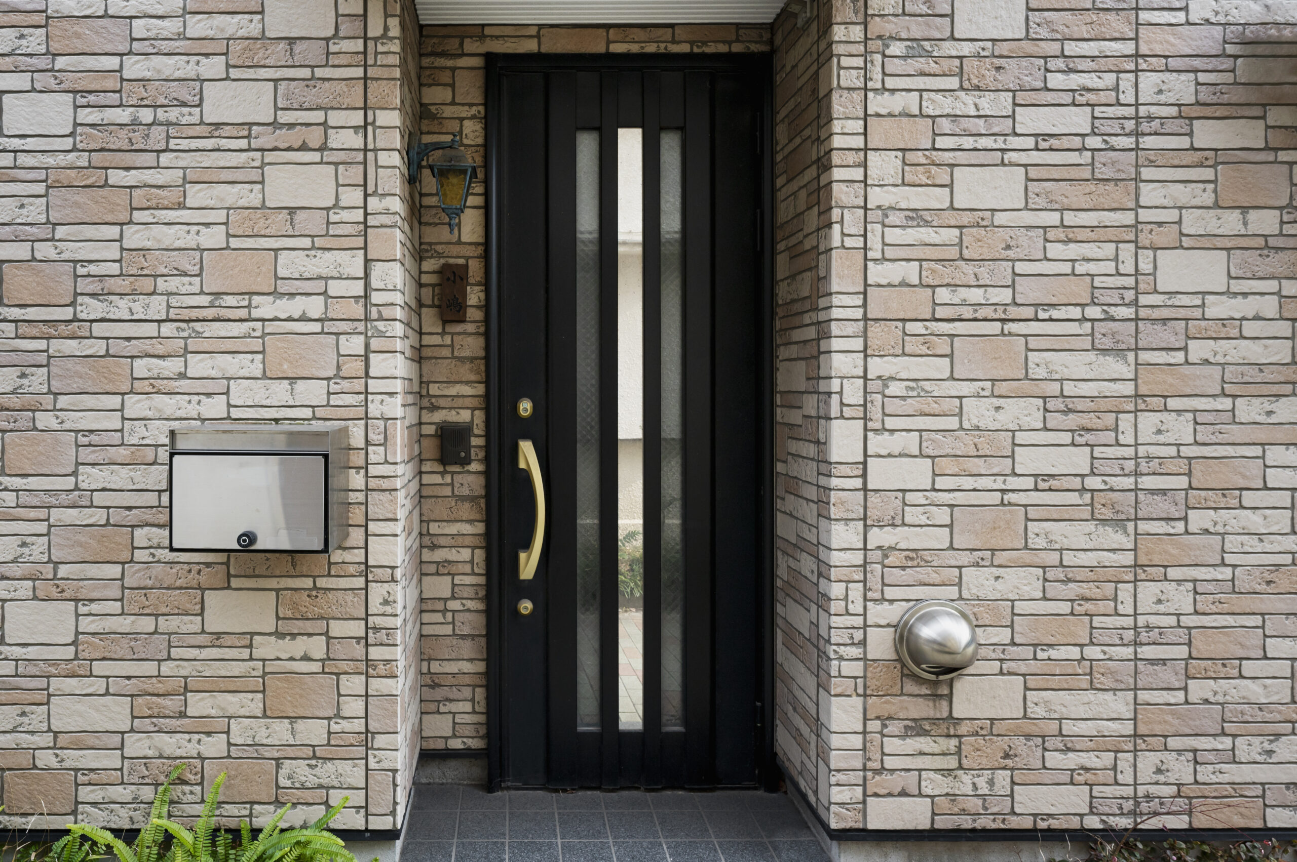 Уличная пластиковая дверь с вертикальным остеклением и декоративной фурнитурой