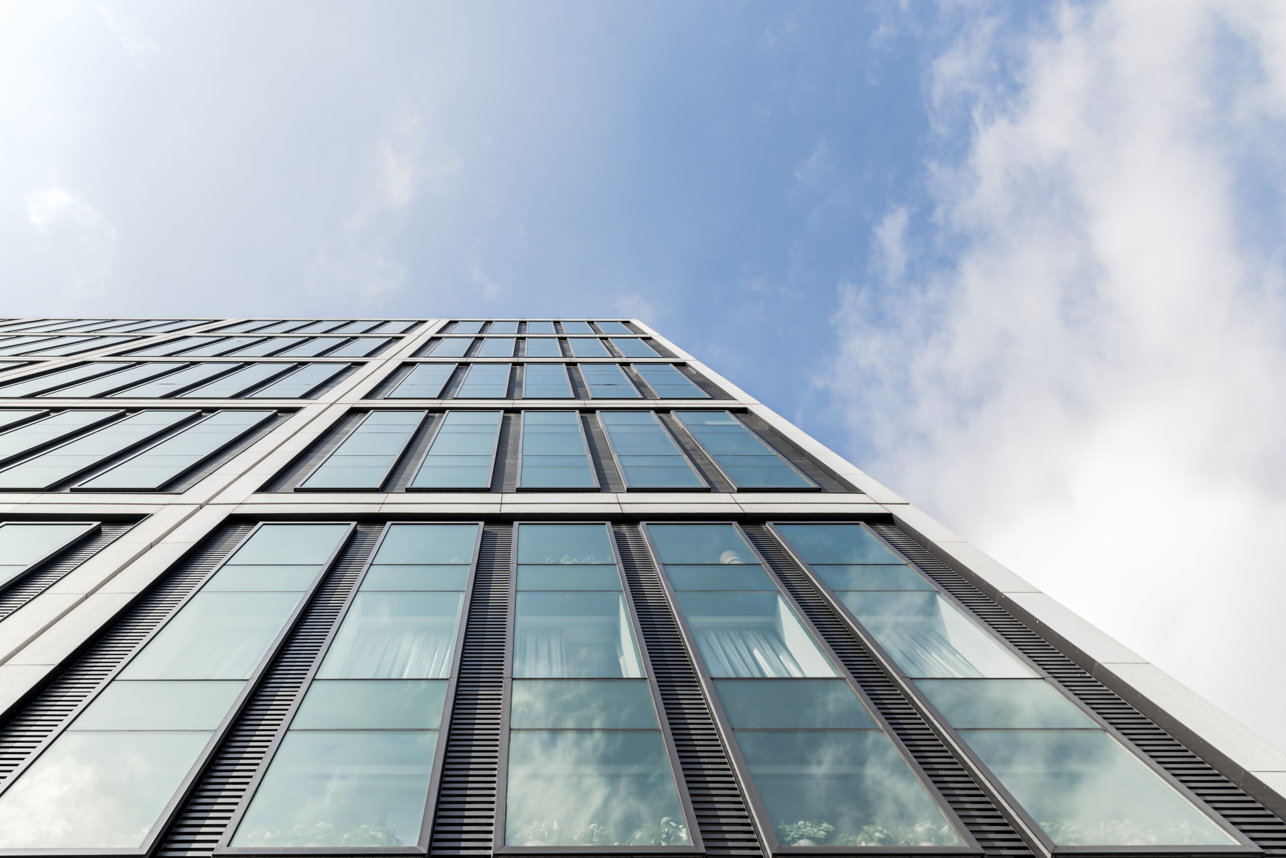 Современное фасадное остекление высотного здания с алюминиевыми профилями и панорамными окнами